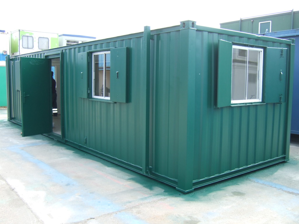 A green used site cabin with windows