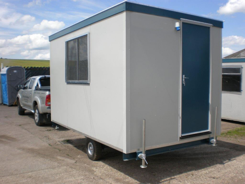 A grey mobile site accommodation unit attached to a car