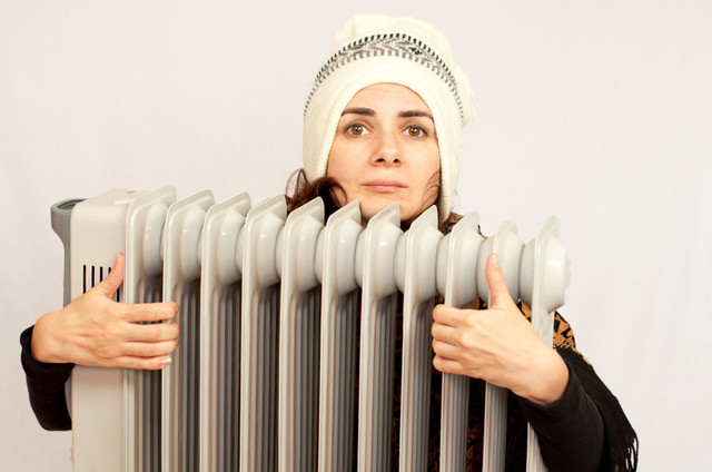 Woman-freezing-near-the-heater-i-Stock-000046326118-Small