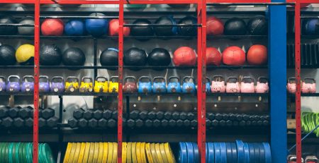 Sports equipment and gym equipment on shelving units