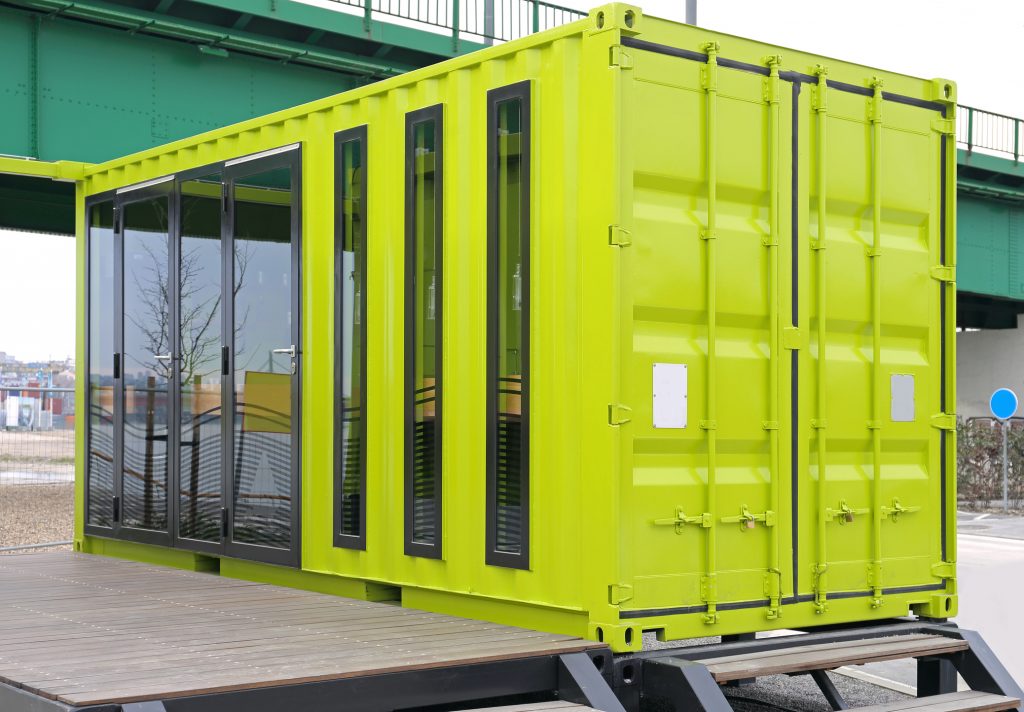 Green Cargo Container Converted For Garden Room with glass doors and windows 