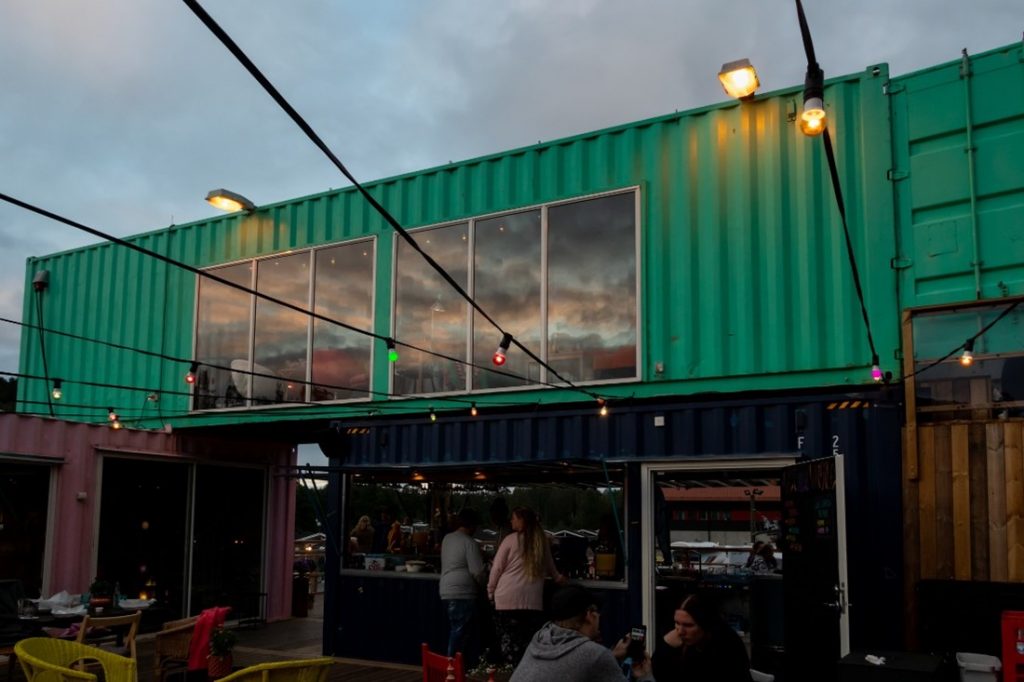 Shipping containers that are stack upon one another. A long green container has two windows