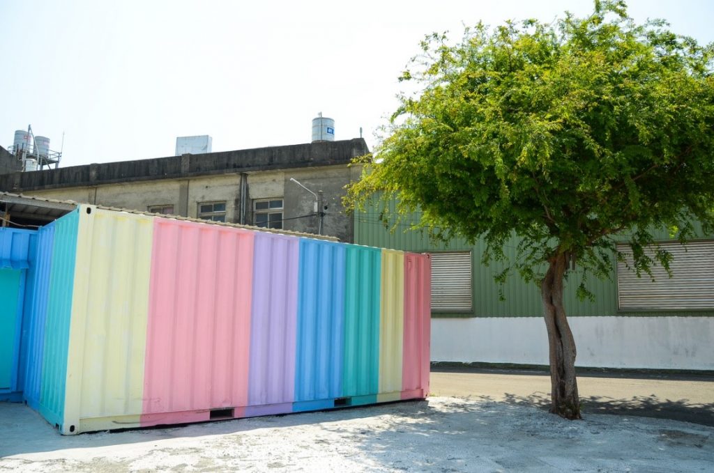 A colorful container next to a tree