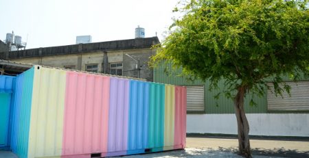 A colorful container next to a tree